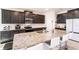 Spacious kitchen with dark cabinetry, granite counters, large island, and modern appliances at 16606 Barnwood Pl, Bradenton, FL 34211