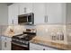 Bright kitchen boasts white cabinets, granite counters, and stainless steel appliances at 2520 Avolet Ct, Bradenton, FL 34211