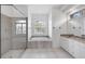 Modern bathroom featuring a glass-enclosed shower, soaking tub, and vanity with marble countertop at 455 Park Trace Blvd, Osprey, FL 34229