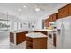 Open kitchen with a breakfast bar, white countertops, and wooden cabinets overlooks living space at 455 Park Trace Blvd, Osprey, FL 34229