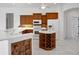 Traditional kitchen featuring wood cabinets, white appliances, and a functional center island with wine storage at 455 Park Trace Blvd, Osprey, FL 34229