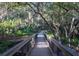 Walking path featuring wood railing, trees, shade, and outdoor space at 455 Park Trace Blvd, Osprey, FL 34229