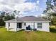 Single-story house with covered patio and grassy yard at 5611 Nymph Ave, North Port, FL 34288