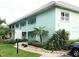 Quaint two-story condo building exterior with lush landscaping and walkways at 611 Gulf N Dr # D24, Bradenton Beach, FL 34217