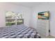 Bedroom featuring a dresser, TV and large windows at 6591 Fairway Gardens Dr # 2-102, Bradenton, FL 34203