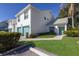 Two-story condo with teal accents, attached garage, and landscaped lawn at 6591 Fairway Gardens Dr # 2-102, Bradenton, FL 34203