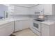 Bright kitchen with white cabinets, appliances, and light wood flooring at 6591 Fairway Gardens Dr # 2-102, Bradenton, FL 34203