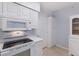 White kitchen with an adjacent pantry and microwave at 6591 Fairway Gardens Dr # 2-102, Bradenton, FL 34203