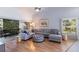 Spacious living room with sectional sofa, wood floors, and access to a patio at 6591 Fairway Gardens Dr # 2-102, Bradenton, FL 34203