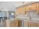 Well-equipped kitchen with light wood cabinets and a double sink at 750 N Tamiami Trl # 302, Sarasota, FL 34236