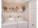 Laundry room with side-by-side washer and dryer and shelving at 750 N Tamiami Trl # 302, Sarasota, FL 34236