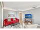 Living area with red couch, white chairs, and large TV at 750 N Tamiami Trl # 302, Sarasota, FL 34236