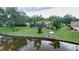 Aerial view of a canal-front home with a pool, lush landscaping, and dock at 915 S Doral Ln, Venice, FL 34293