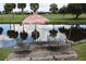 View of the backyard with a colorful umbrella over two chairs on the water at 915 S Doral Ln, Venice, FL 34293