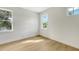 Simple bedroom with hardwood floors and two large windows at 2492 S Milmar Dr, Sarasota, FL 34237