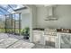 Outdoor kitchen with stainless steel appliances and screened enclosure at 2492 S Milmar Dr, Sarasota, FL 34237