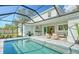 Covered patio with pool, outdoor kitchen, and seating area at 2492 S Milmar Dr, Sarasota, FL 34237