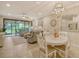 Open concept dining area with white round table and chairs, overlooking the living room and patio at 13604 Messina Loop # 103, Lakewood Ranch, FL 34211