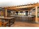 Long bar with wooden pergola and comfortable seating at 13604 Messina Loop # 103, Lakewood Ranch, FL 34211