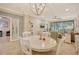 Bright dining area with white table and chairs, view to living room and sliding doors to patio at 13604 Messina Loop # 103, Lakewood Ranch, FL 34211