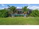 Serene pool and garden area with palm trees and well-manicured landscaping at 23095 Langdon Ave, Port Charlotte, FL 33954