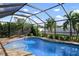 Inviting pool area with screened enclosure, lounge chairs, and lush landscaping at 23095 Langdon Ave, Port Charlotte, FL 33954