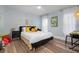 Bright bedroom with a queen bed, yellow accents, and wood-look floors at 23095 Langdon Ave, Port Charlotte, FL 33954