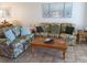 Living room with floral patterned sofas, coffee table, and wood end tables at 3935 Lake Bayshore Dr # F-316, Bradenton, FL 34205