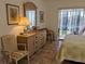 Bedroom with dresser, chair, and access to balcony at 3935 Lake Bayshore Dr # F-316, Bradenton, FL 34205