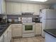 White cabinets, dark countertops, and full-size appliances at 3935 Lake Bayshore Dr # F-316, Bradenton, FL 34205