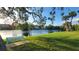 Serene lakefront view with a peaceful bench, lush greenery, and mature trees at 4924 Live Oak Cir # 115, Bradenton, FL 34207