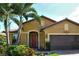 Tan house with red door, brown garage door, and landscaping at 5325 Sundew Dr, Sarasota, FL 34238