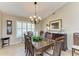 Formal dining room with wood table, chandelier, and large windows at 5663 Country Lakes Dr, Sarasota, FL 34243