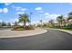 Landscaped entrance to the community with palm trees and a clubhouse at 5717 Cheech Gln, Bradenton, FL 34211