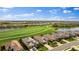 Aerial view showing a neighborhood with houses near a golf course and lake at 5717 Cheech Gln, Bradenton, FL 34211