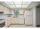 View of kitchen with white cabinets and appliances and a view to the living room at 6515 Heritage Ln # 2615, Bradenton, FL 34209