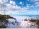 Scenic beach access with white sand and dunes at 6901 Poinsettia Ave, Longboat Key, FL 34228