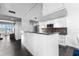 Modern white kitchen with stainless steel appliances and breakfast bar at 800 N Tamiami Trl # 321, Sarasota, FL 34236