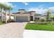 Tan house with a two-car garage and a paved driveway at 10128 Morning Mist Ln, Sarasota, FL 34241