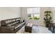 Cozy living room featuring a plush leather sofa, ottoman, and a large window offering natural light at 10128 Morning Mist Ln, Sarasota, FL 34241