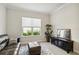Bright living room with modern decor, including a leather sofa, ottoman, and sunlit window at 10128 Morning Mist Ln, Sarasota, FL 34241