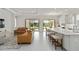 Spacious living room and kitchen combo featuring an island with barstool seating and two sliding glass doors to the backyard at 10128 Morning Mist Ln, Sarasota, FL 34241