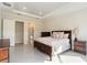 Bright and airy main bedroom with tray ceiling, a king bed, and view to ensuite bathroom at 10128 Morning Mist Ln, Sarasota, FL 34241