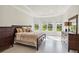 Comfortable main bedroom with bay window and view to backyard, features a king bed and dark wood furnishings at 10128 Morning Mist Ln, Sarasota, FL 34241