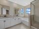 Bathroom with double vanity, soaking tub, and glass shower at 17015 Harvest Moon Way, Bradenton, FL 34211
