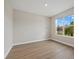 Spacious bedroom featuring wood-look floors and a large window with a view at 17015 Harvest Moon Way, Bradenton, FL 34211