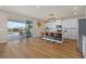Open kitchen with island, white cabinets, and view of pool at 17015 Harvest Moon Way, Bradenton, FL 34211