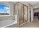 Bathroom with soaking tub, walk-in shower, and access to closet at 17015 Harvest Moon Way, Bradenton, FL 34211