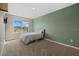 Bedroom with light green accent wall and a window overlooking the neighborhood at 17015 Harvest Moon Way, Bradenton, FL 34211