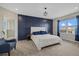 Main bedroom with a large bed, navy feature wall, and ensuite bathroom at 17015 Harvest Moon Way, Bradenton, FL 34211